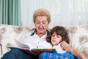 30411891 - nice elderly woman grandmother reading story to sweet young granddaughter