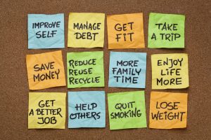 24384461 - popular new year resolutions - colorful sticky notes on a cork board