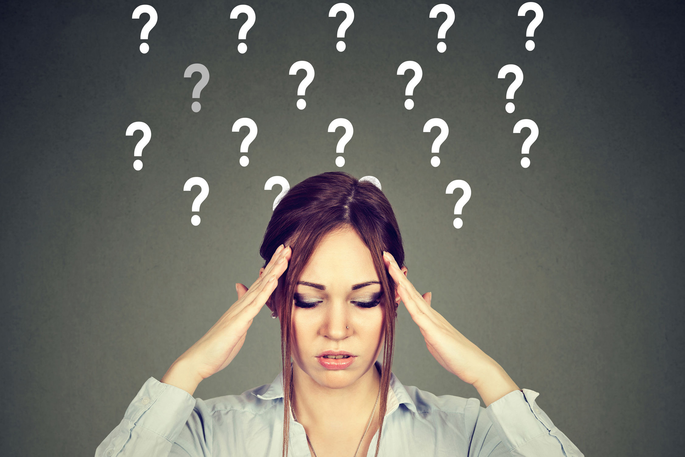 79952173 - anxious stressed woman with question marks on gray background